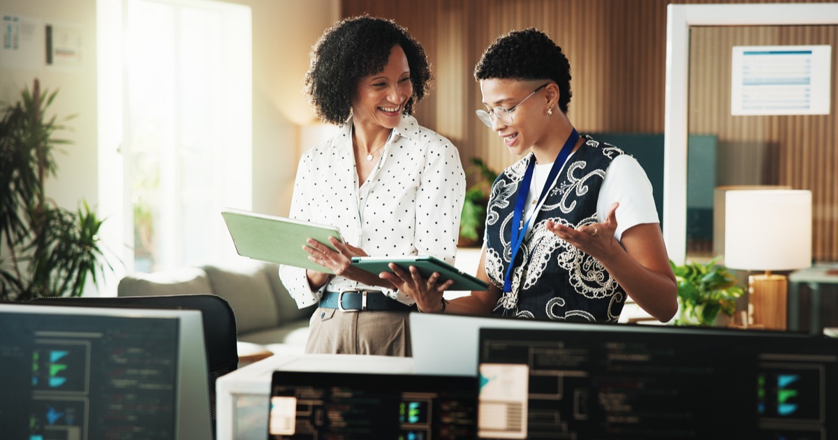 Technology consultants reviewing software customization options on tablets