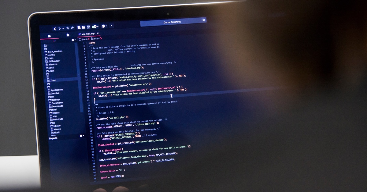 Laptop displaying WordPress code for a custom plugin versus SaaS decision