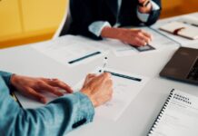 Designing a Quote Intake API Around Your ERP Business professionals reviewing and signing a project proposal
