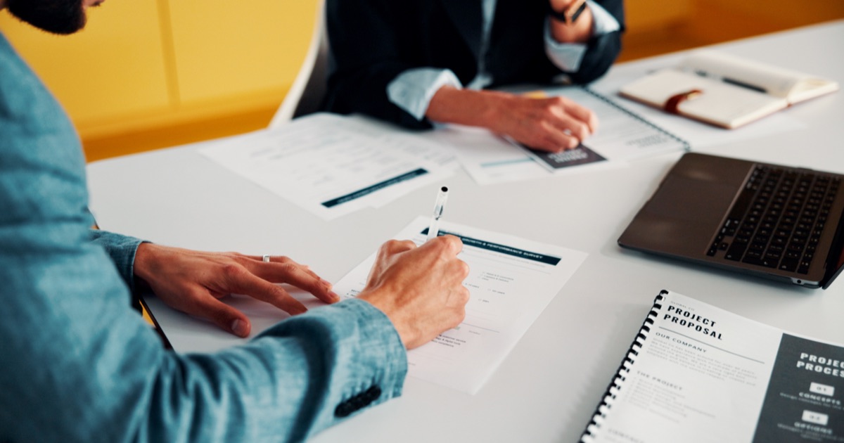 Business professionals reviewing and signing a project proposal