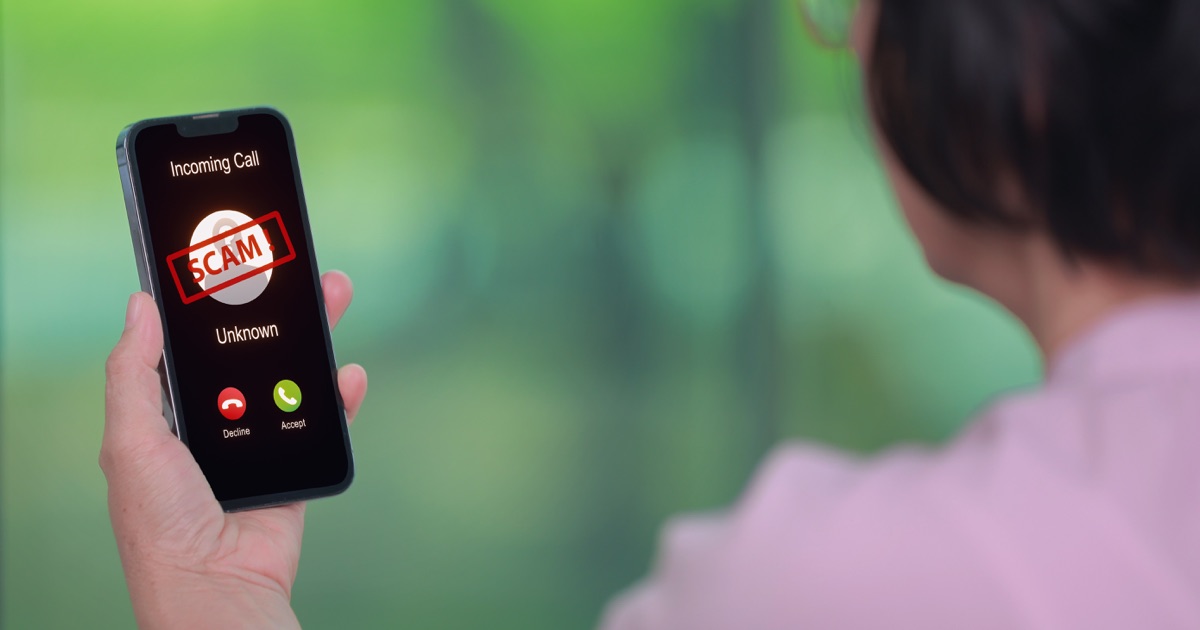 Phone displaying a scam call warning for online and phone scam protection