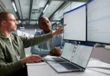 Real Time vs Batch Integrations, How to Decide What Needs Live Data Software engineers comparing system data across multiple monitors