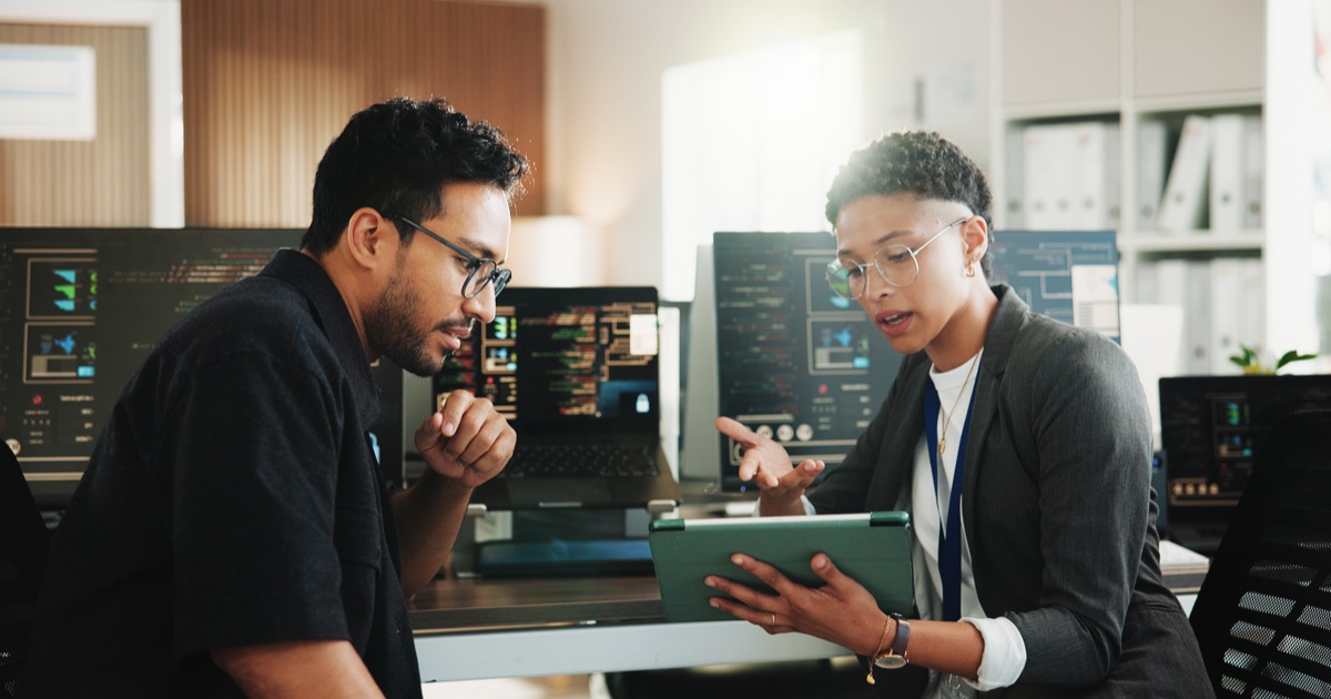 Developers reviewing database information on a tablet in an office